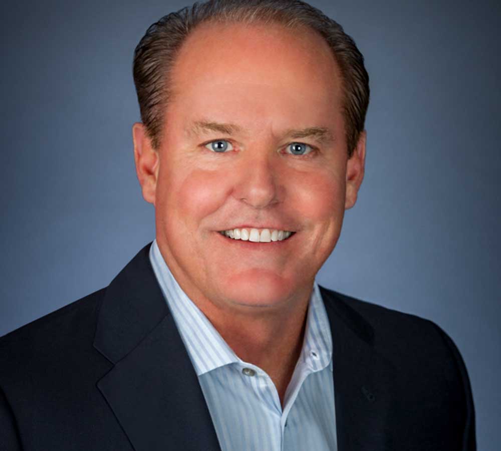 Headshot of Jack McGregor wearing light blue collared shirt and dark blazer